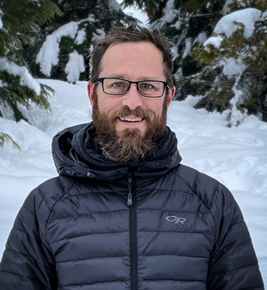 Man with beard standing in snow