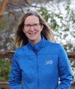 Blond woman in blue coat smiling