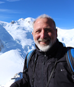 Man with white beard standing at mountain top