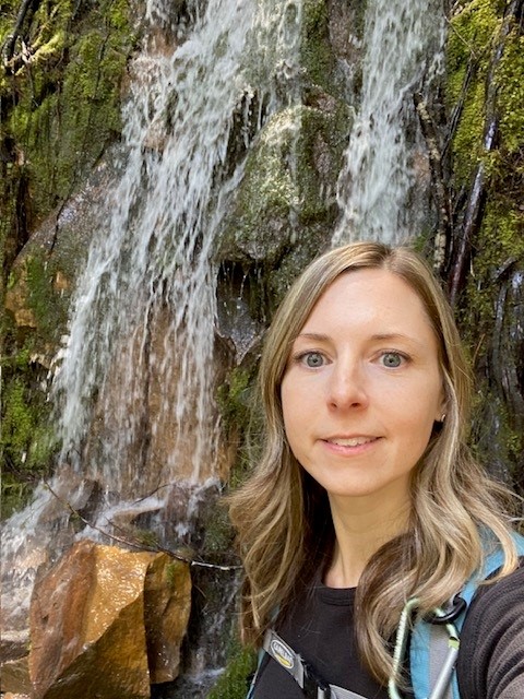 Woman standing in front of a waterfall