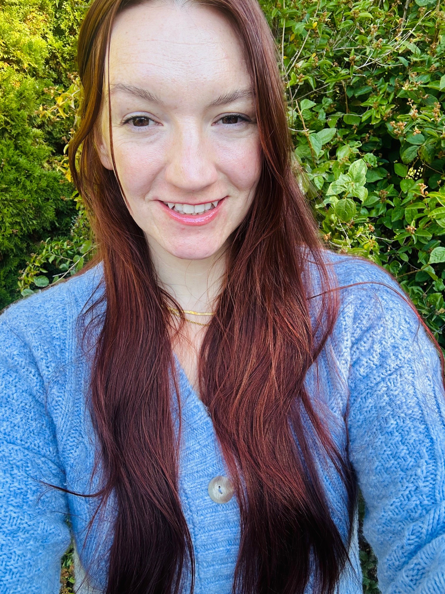Red-headed woman wearing a blue sweater while smiling